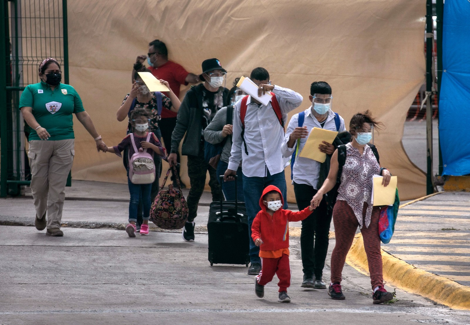 Asylum seekers walk to the U.S.-Mexico border as a group of at least 25 immigrants were allowed to travel from a migrant camp in Mexico into the United States on February 25, 2021 in Matamoros, Mexico. (Photo by John Moore/Getty Images)
