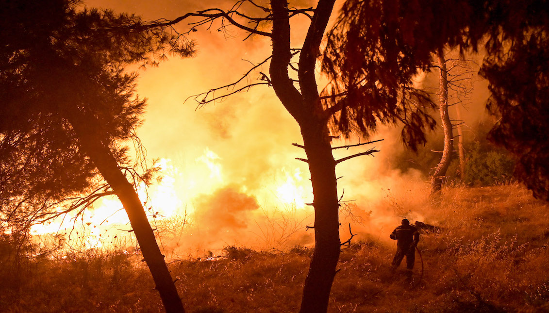 Firefighters try to put out a fire as flames spread over a highway during a wildfire on August 5 2021 in northern Athens , Greece. People were evacuated from their homes after a wildfire reached residential areas of northern Athens as record temperatures reached 42 degrees Celsius (107.6 Fahrenheit). Photo: Milos Bicanski/Getty Images
