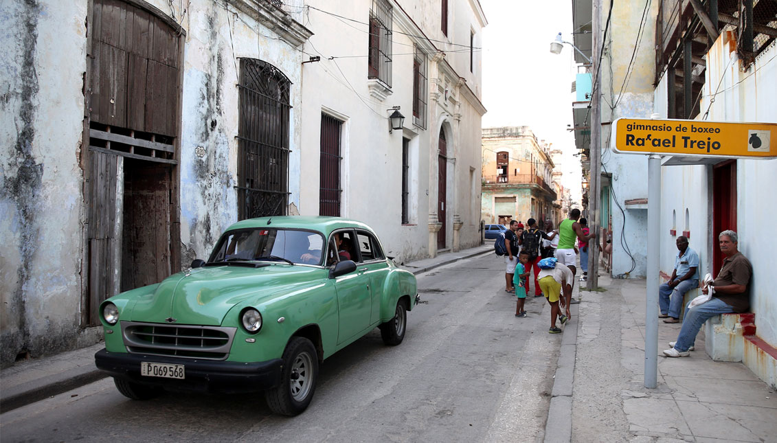 An old car drives past the front of the Rafael Trejo Boxing Gym on May 12, 2015 in Havana, Cuba.  (Photo by Ezra Shaw/Getty Images)