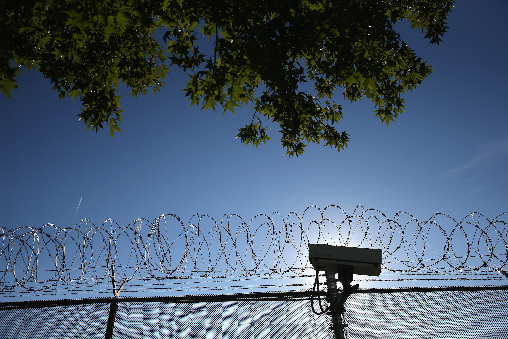 Concertina wire and a security camera line the perimiter of the York County Dentention Center as immigration reform activists protest on September 15, 2015 in York, Pennsylvania. Photo: John Moore/Getty Images.
