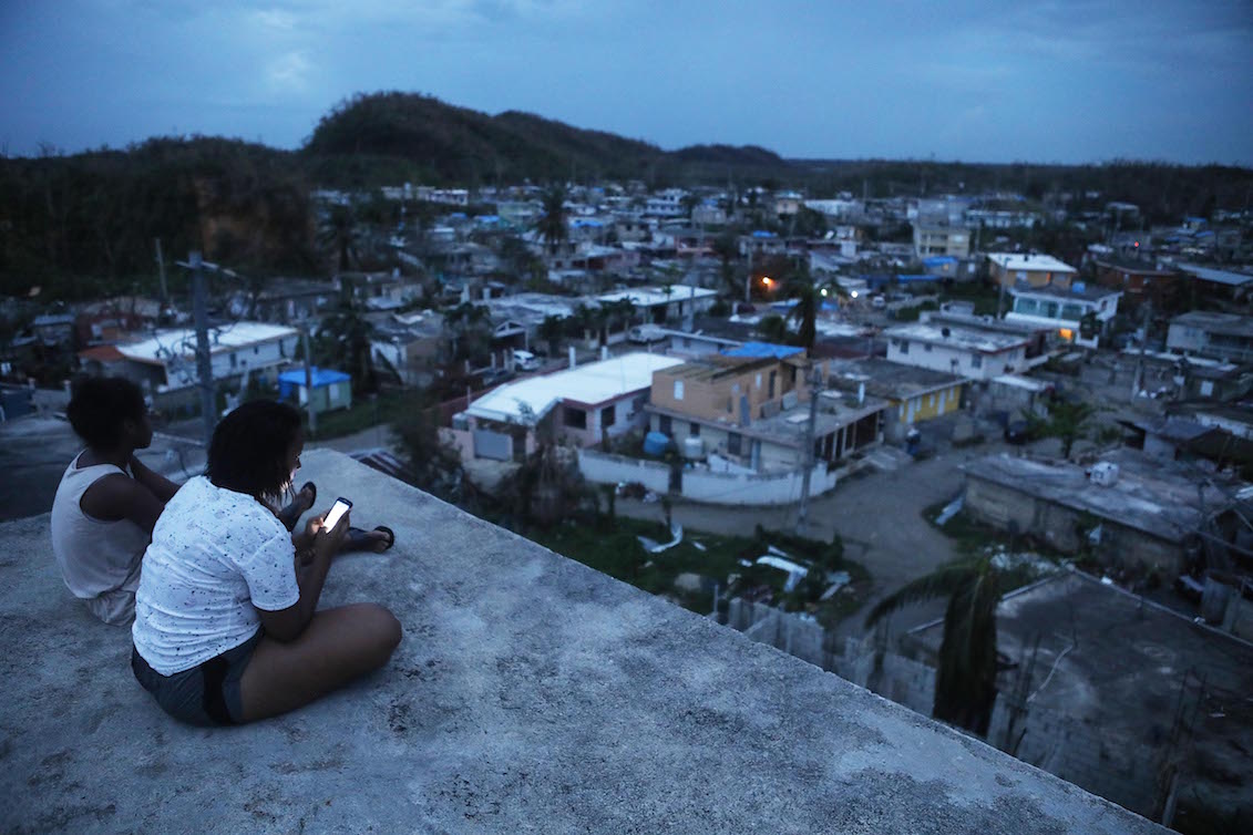 A resident checks her cell phone on her rooftop at dusk about two weeks after Hurricane Maria swept through the island on October 5, 2017 in San Isidro, Puerto Rico. Photo: Mario Tama/Getty Images