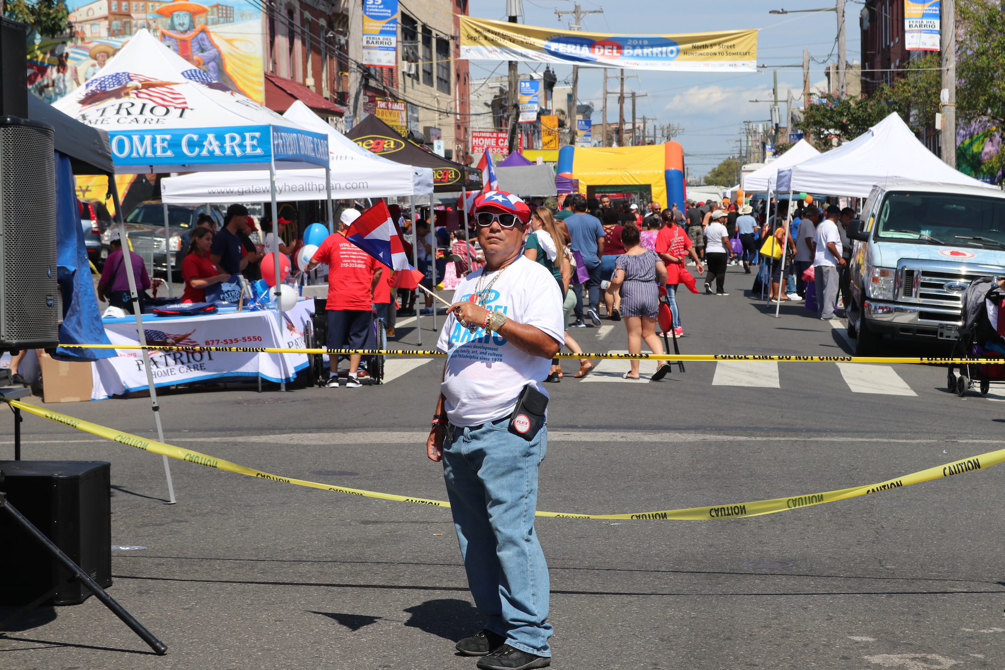 A festive attendee waves a Puerto Rican flag near the performance stage at Feria del Barrio on September 8. Photo: Nigel Thompson/AL DÍA News.