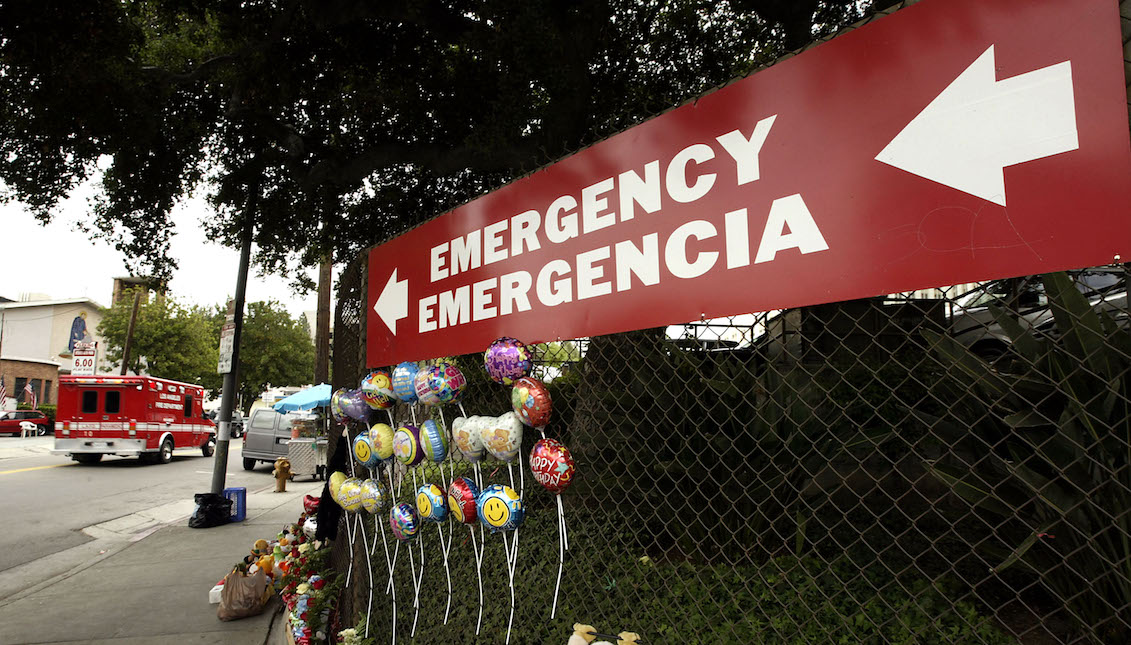 LOS ÁNGELES - 17 DE MAYO: Una ambulancia acelera más allá de una señal que apunta a la entrada de emergencia del Centro Médico USC del Condado de Los Ángeles, tanto en inglés como en español, el 17 de mayo de 2004 en Los Ángeles, California. (Foto por David McNew/Getty Images)