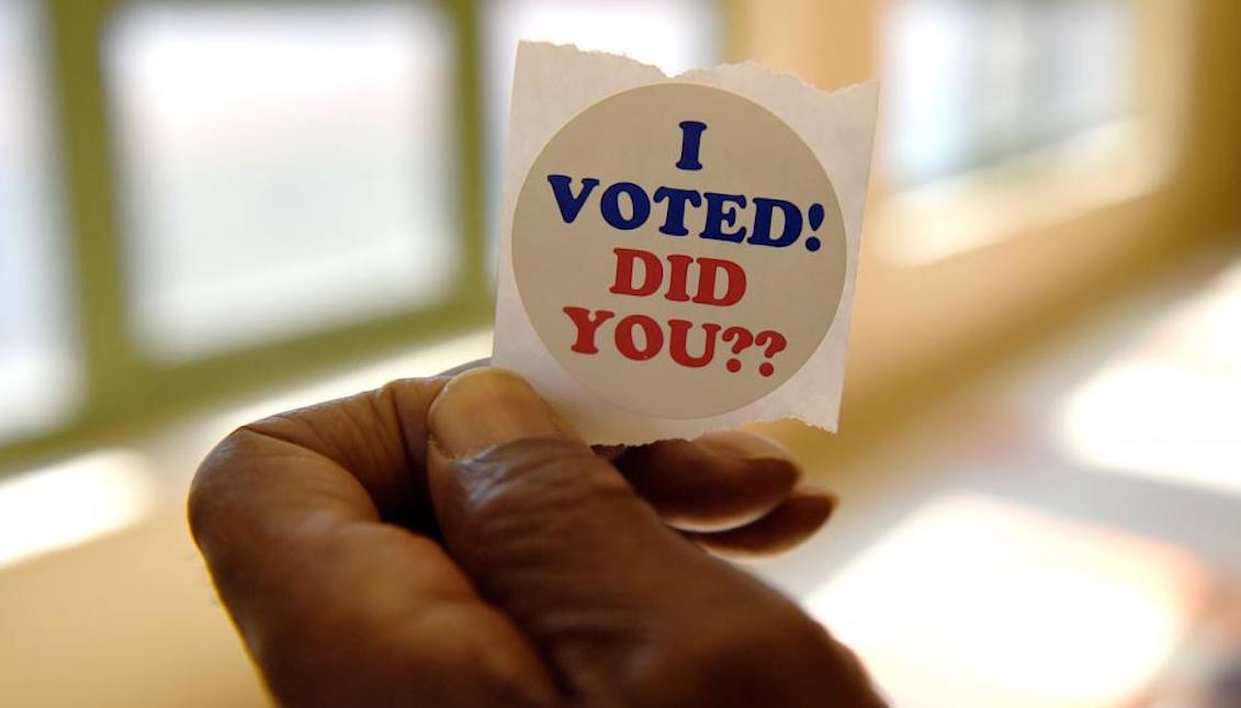 A Detroit resident shows his sticker after voting in a polling place at Edmonson Academy in Detroit, Michigan, March 8, 2016. File Photo by Molly Riley/UPI