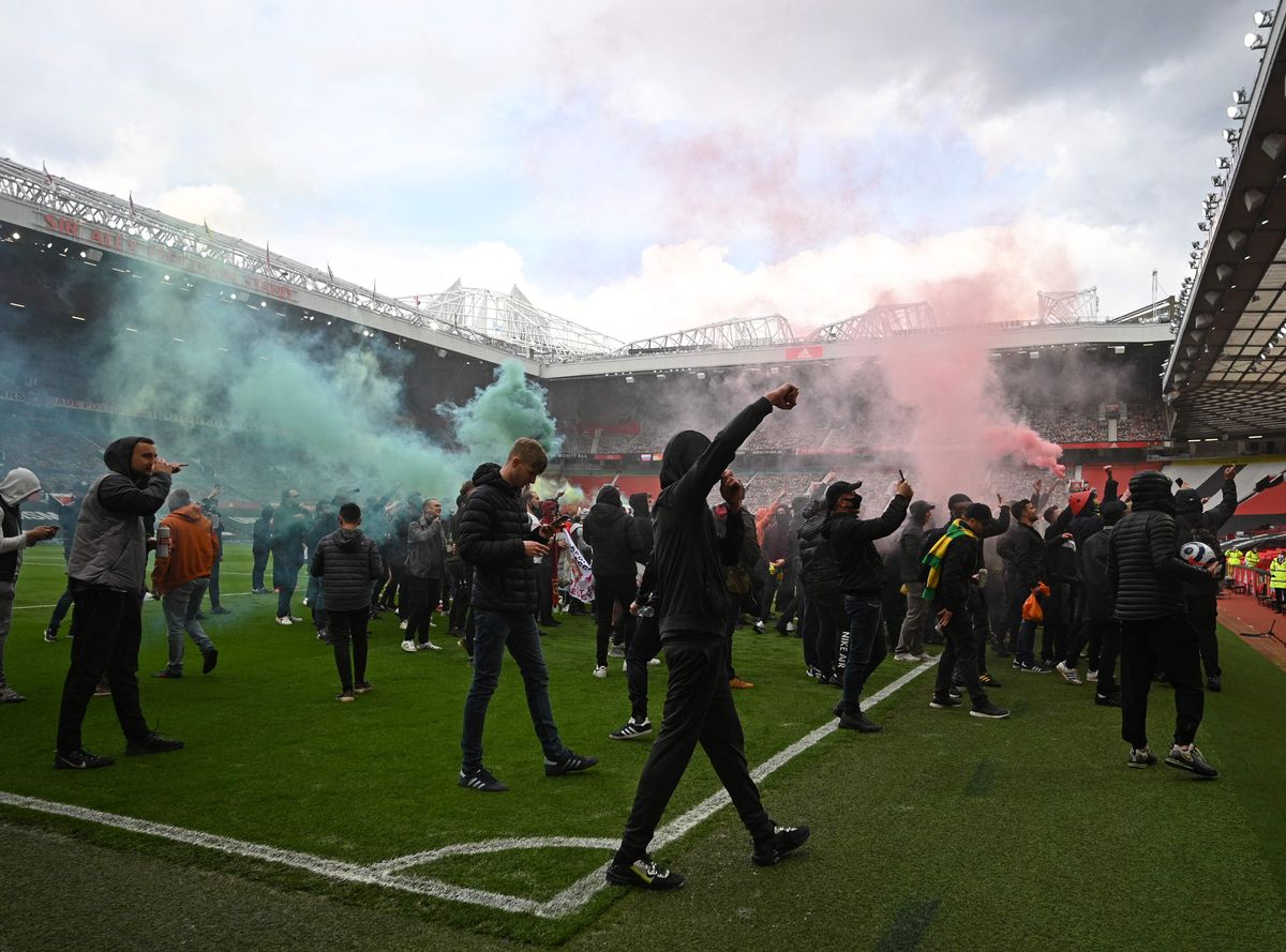 United fans on the Old Trafford pitch. REUTERS