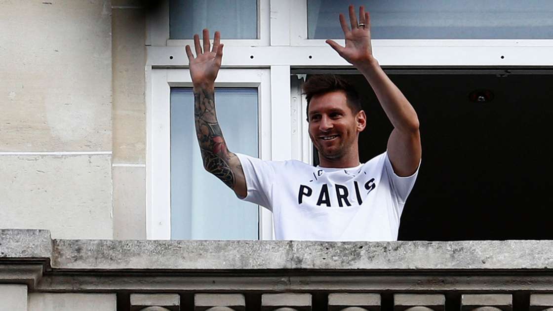 Argentinian football player Lionel Messi waves at fans from a balcony of the Royal Monceau hotel in Paris on August 10, 2021, as the football legend is expected to sign an initial two-year deal with Paris Saint-Germain football club following his departure from boyhood club Barcelona. Photo: Sameer Al-Doumy/AFP via Getty Images.
