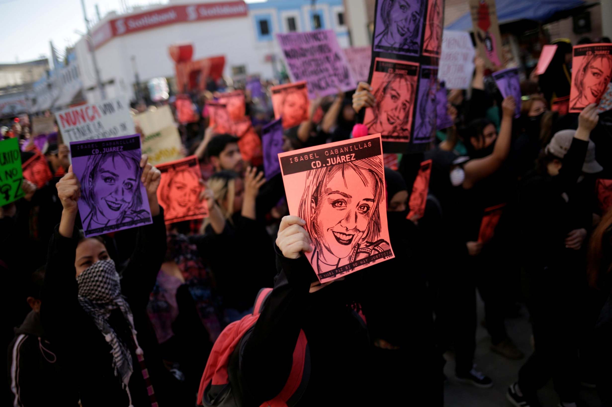 Protestors hold different colored papers showing a drawing of Isabel Cabanillas' face as they take to the street. Photo: Reuters. 