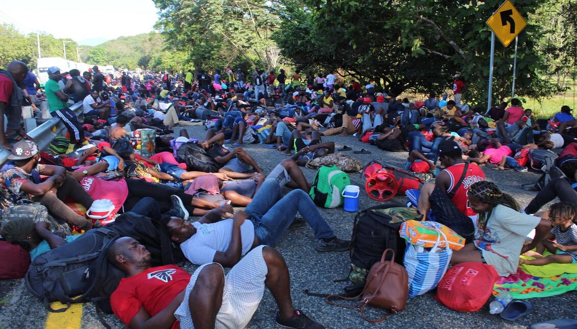 migrantes haitianos rumbo a Estados Unidos descansando en una vía de México