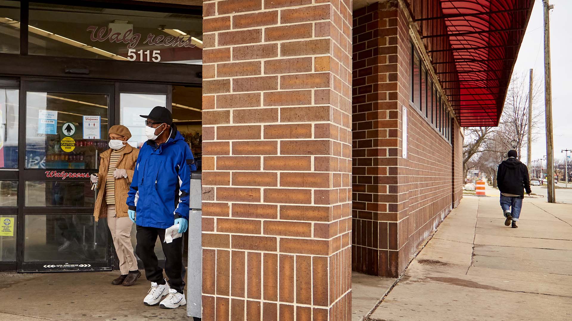 A couple wearing face coverings and wearing rubber gloves leave a Walgreens in Milwaukee, Wisconsin. Photo: Darren Hauck / ProPublica.