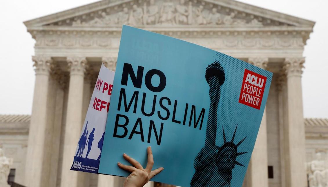 Protesters rally outside the U.S. Supreme Court in Washington, DC, U.S., April 25, 2018, while the court justices consider case regarding presidential powers as it weighs the legality of President Donald Trump's latest travel ban targeting people from Muslim-majority countries. REUTERS/Yuri Gripas