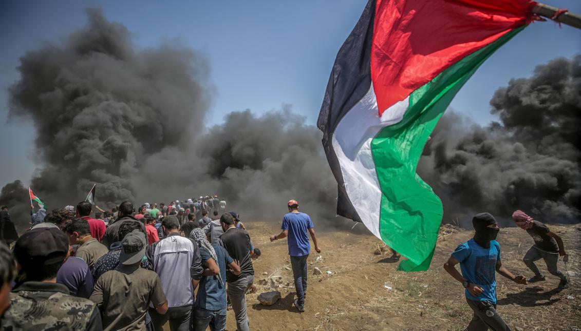 Protesters run to protect themselves from the tear gas thrown by Israeli soldiers during protests on the Gaza-Israel border on Monday, May 14, 2018. EFE / Mohammed Saber