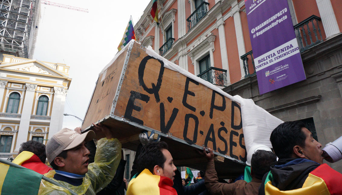 Anti-Morales demonstrators hold a box simulating a coffin with the name of Evo Morales at former government house Palacio Quemado on November 10, 2019 in La Paz, Bolivia. Photo by Javier Mamani/Getty Images
