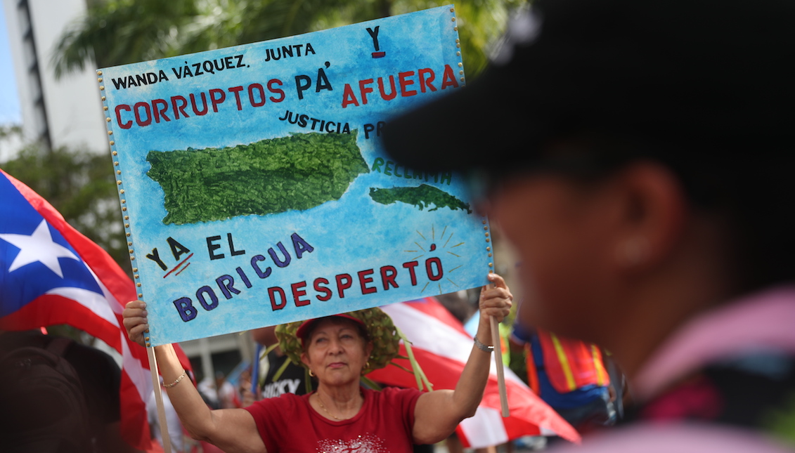 SAN JUAN, PUERTO RICO - JULY 25: People march through the financial district as they celebrate the ouster of Ricardo Rossello, the Governor of Puerto Rico, on July 25, 2019 in Old San Juan, Puerto Rico. (Photo by Joe Raedle/Getty Images)