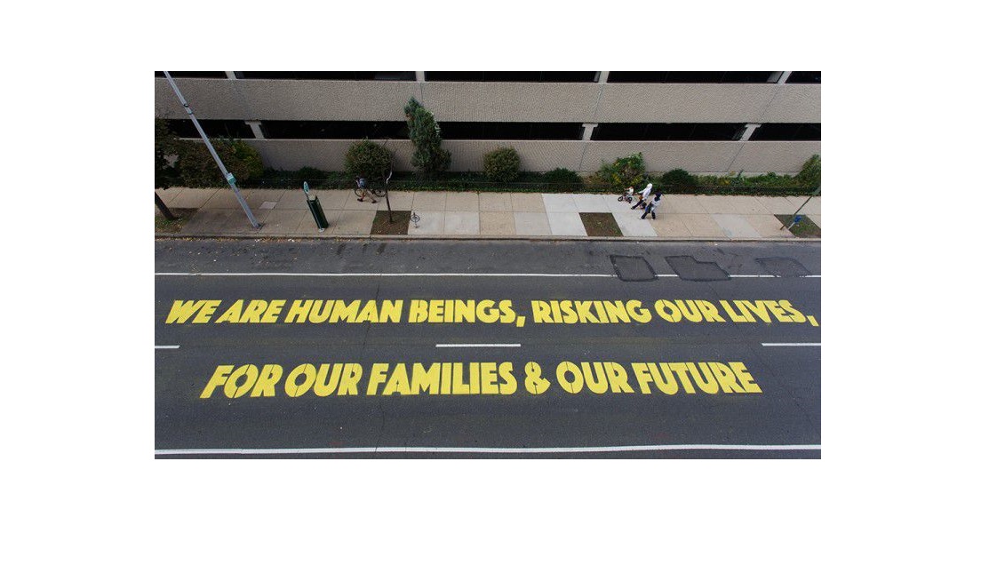 "We Are Human Beings" installed in front of the ICE building in Philadelphia. A work by Latino artist Michelle Angela Ortiz. Photo Credit: Steve Weinik