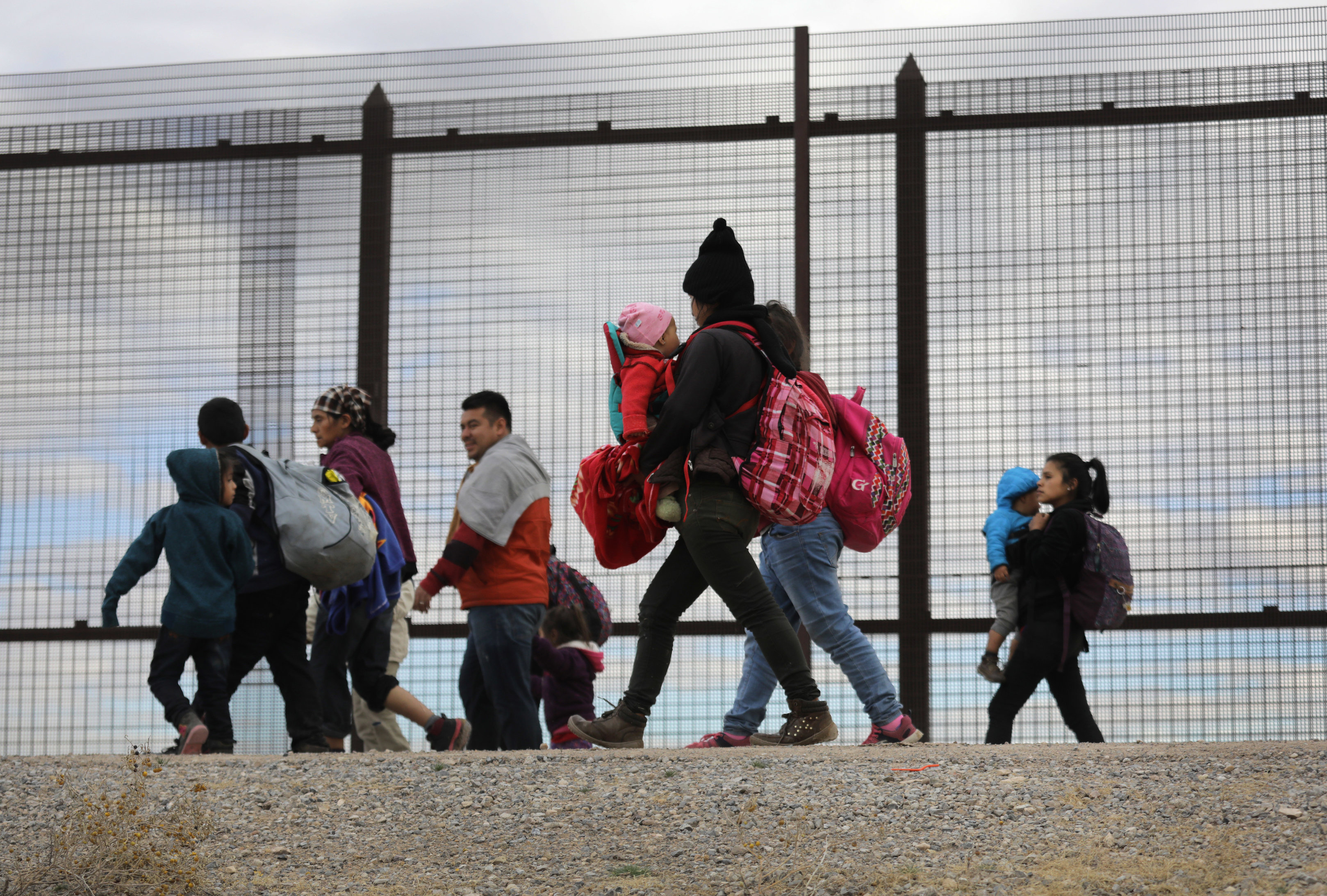 EL PASO, TEXAS - FEBRUARY 01: Central American immigrants walk along the border fence after crossing the Rio Grande from Mexico on February 01, 2019 in El Paso, Texas. The migrants later turned themselves in to U.S. Border Patrol agents, seeking political asylum in the United States. (Photo by John Moore/Getty Images)