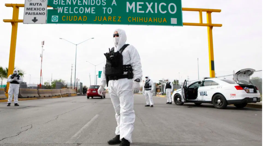 Chihuahua State Police members, wearing protective suits, take part in an information and prevention campaign against the coronavirus -COVID-19- pandemic, at the Cordoba-De las Americas International Bridge in Ciudad Juarez, Chihuahua, Mexico, on March 29, 2020. Photo: Henrika Martinez/Getty Images.
