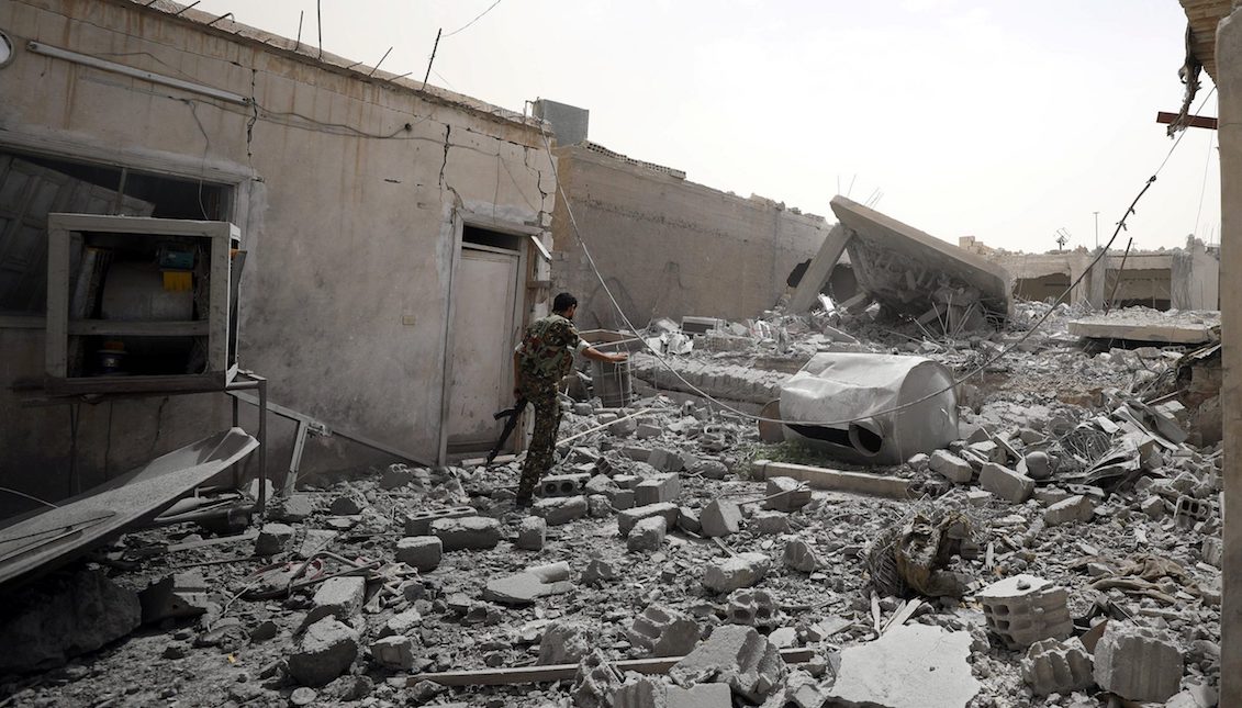 Member of the Syrian Democratic Force walks in the middle of rubble in Raqqa (Rodi Said / Reuters)