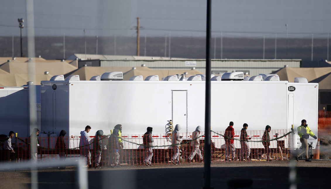 In this Dec. 13, 2018 file photo, migrant teens walk in a line through the Tornillo detention camp in Tornillo, Texas. Andres Leighton—AP