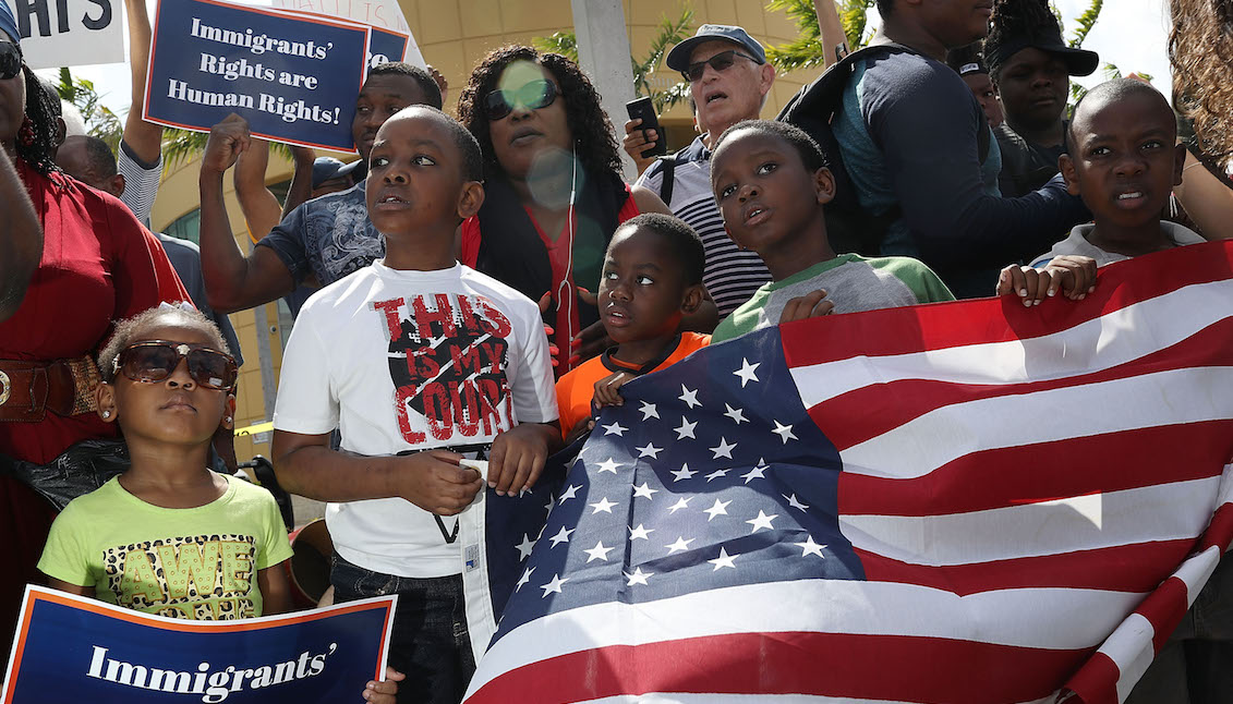 MIAMI, FL - MAY 13: People protest the possibility that the Trump administration may overturn the Temporary Protected Status for Haitians in front of the U.S. Citizenship and Immigration Services office on May 13, 2017, in Miami, Florida. (Photo by Joe Raedle/Getty Images)