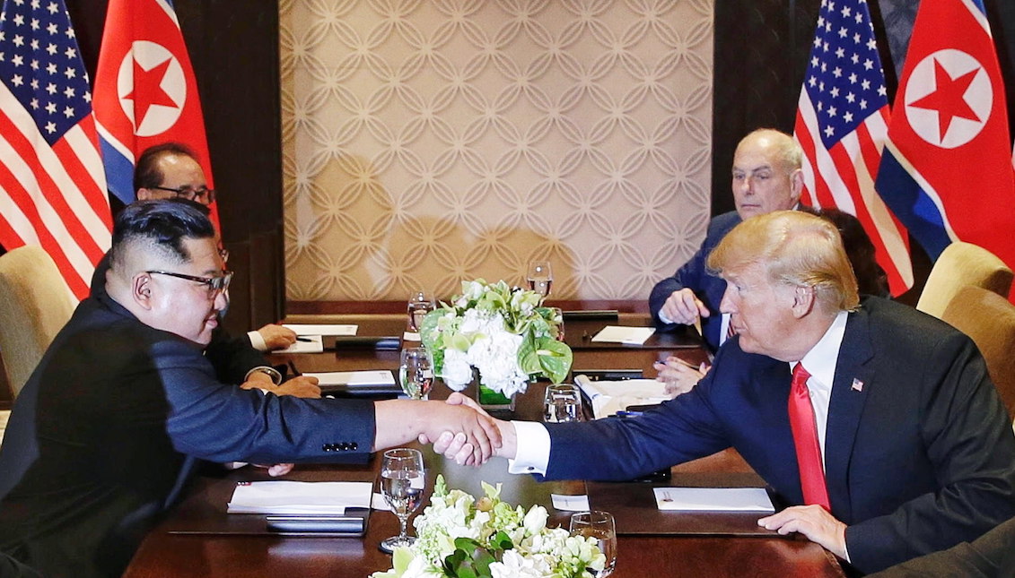 El presidente de los Estados Unidos, Donald J. Trump(d), y el líder norcoreano, Kim Jong-un (i), se dan la mano sobre la mesa durante su histórica cumbre el martes 12 de junio de 2018, en el hotel Capella en la isla de Sentosa (Singapur). EFE/KEVIN LIM/THE STRAITS TIMES/SPH/SOLO USO EDITORIAL