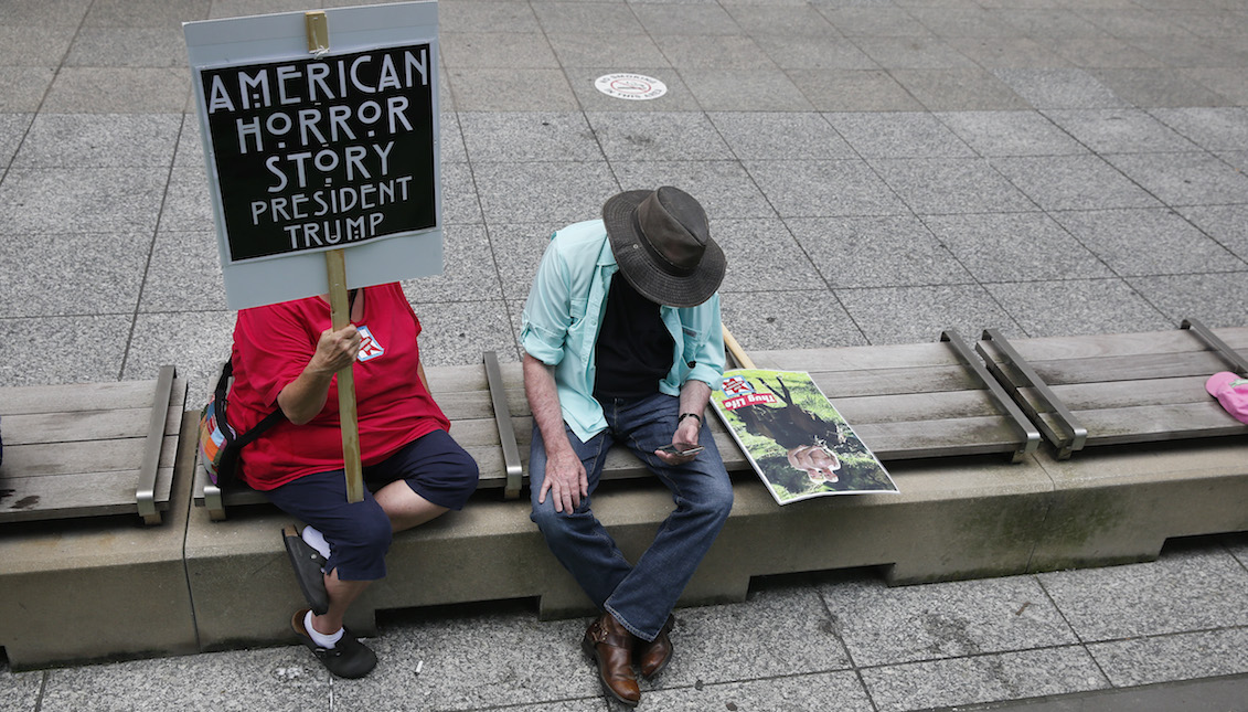 CHICAGO, ILLINOIS - JULY 13: Protesters sitting in the shade during a rally in Daley Plaza on July 13, 2019 in Chicago, Illinois. Protesters attended the rally calling for an end to criminalization, detention and deportations of migrants ahead of planned ICE raids expected this weekend. (Photo by Nuccio DiNuzzo/Getty Images)