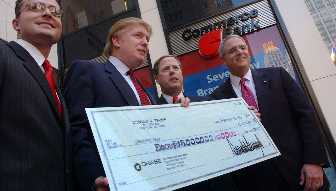 Donald Trump (2nd L) poses with officials from Commerce Bank at an event to promote the opening of two new Commerce Bank branches September 6, 2001, in New York City. Trump made the first deposit of $5 million. (Photo by Spencer Platt/Getty Images)