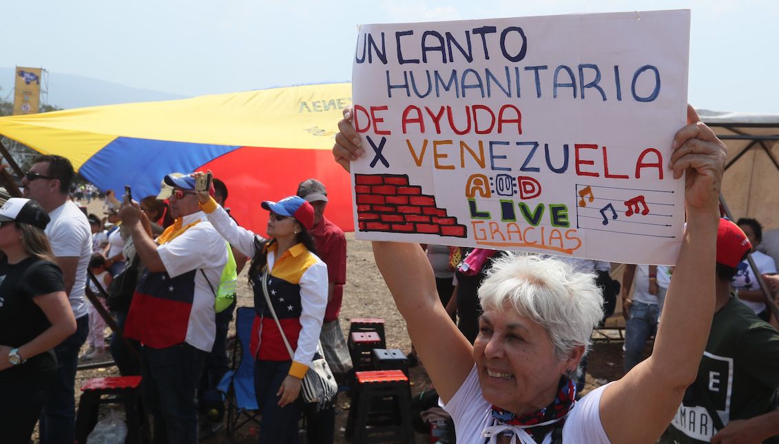 A woman holds a poster during the Venezuela Aid Live concert this Friday at the Tienditas border bridge in Cúcuta (Colombia). EFE/Mauricio Dueñas Castañeda