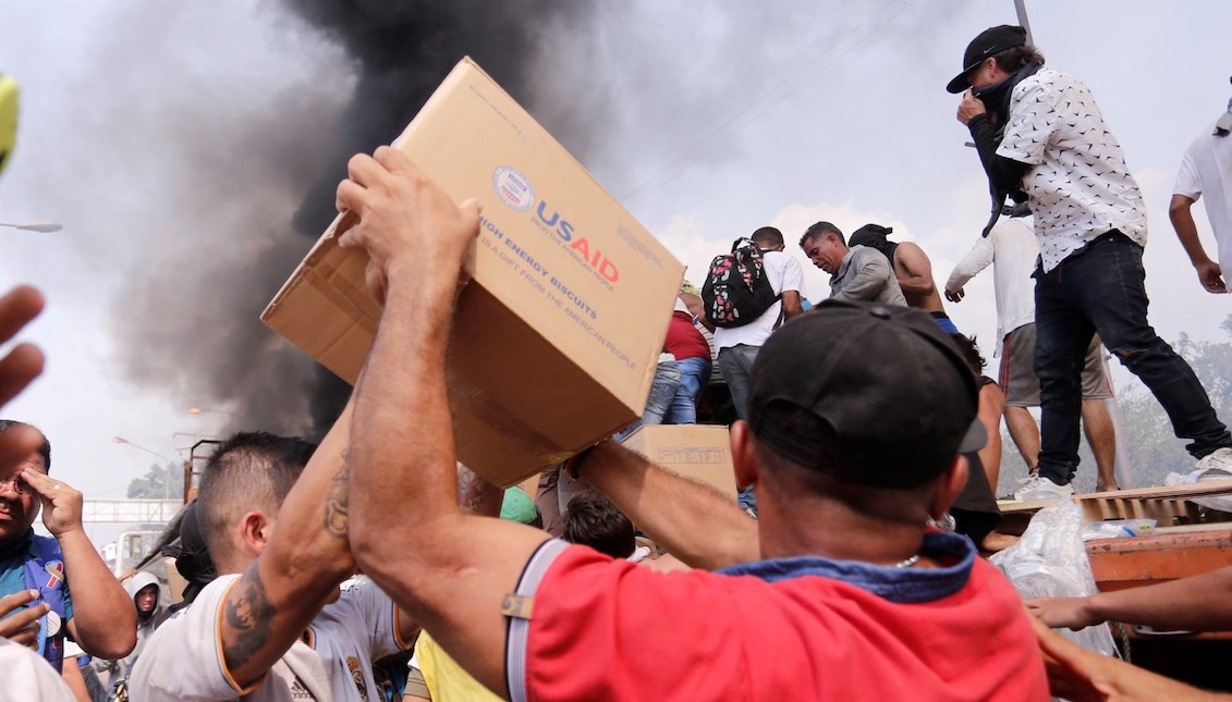 People try to take part of the humanitarian aid that is a truck that was burned, this Saturday, in Ureña (Venezuela). Two trucks with humanitarian aid requested by the opposition were burned by the Bolivarian National Police on the Venezuelan side of the Francisco de Paula Santander bridge, which connects the country with Colombia, deputy Gaby Arellano denounced. EFE/Deibison Torrado