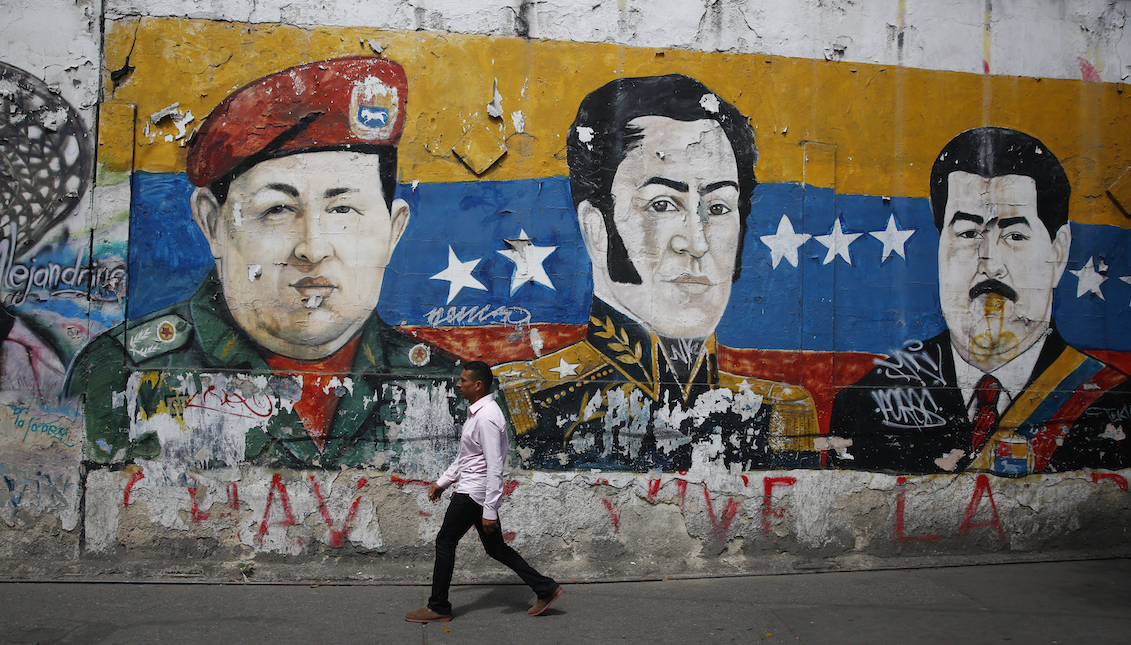 CARACAS, VENEZUELA - JANUARY 30: A man walks past a mural depicting Venezuela's late President Hugo Chávez, Latin American independence hero Simon Bolivar and Venezuela's President Nicolás Maduro on January 30, 2019 in Caracas, Venezuela. (Photo by Marco Bello/Getty Images)