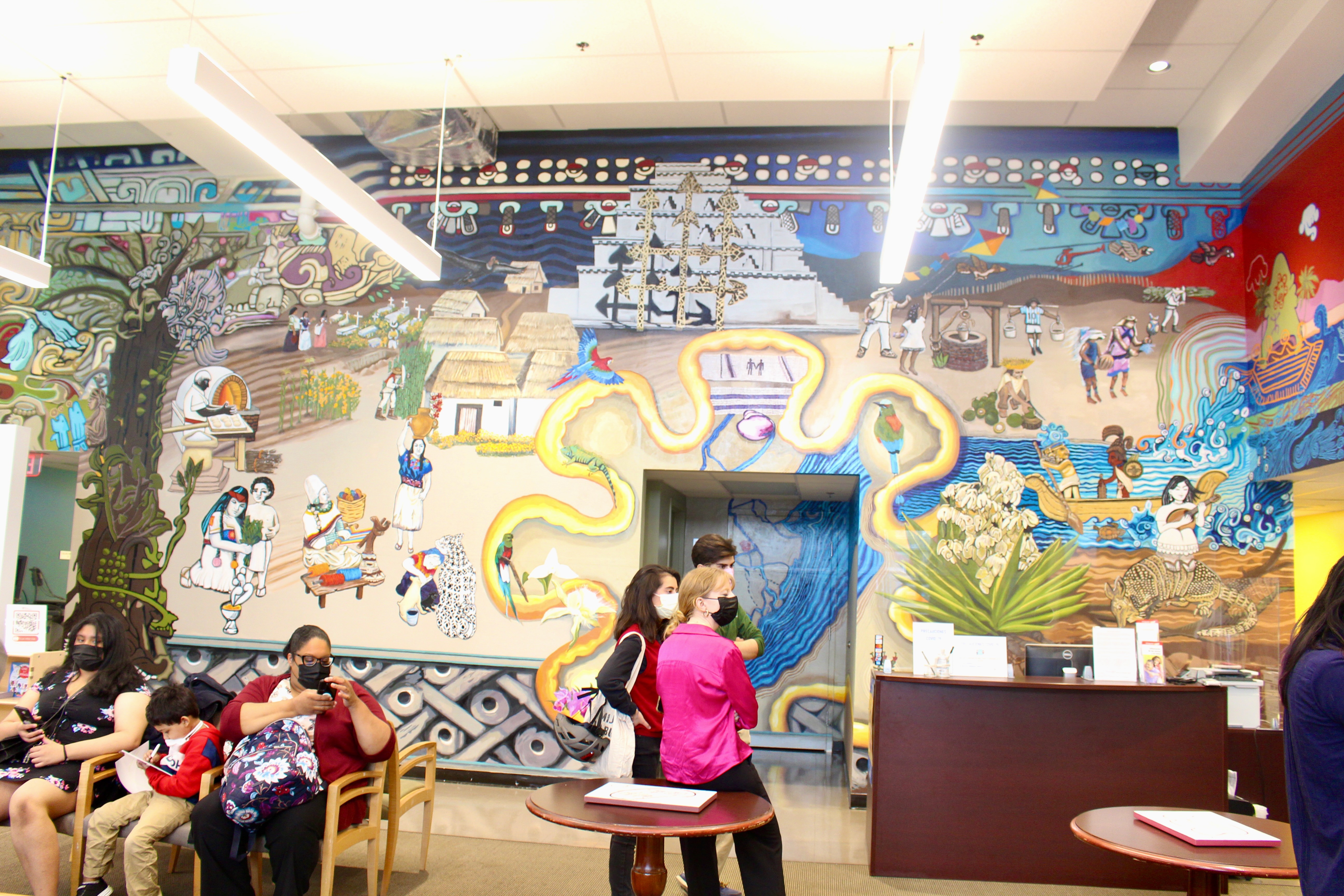 People in front of the white mural during the mural unveiling event. Photo credit: Emily Leopard-Davis/AL DÍA News